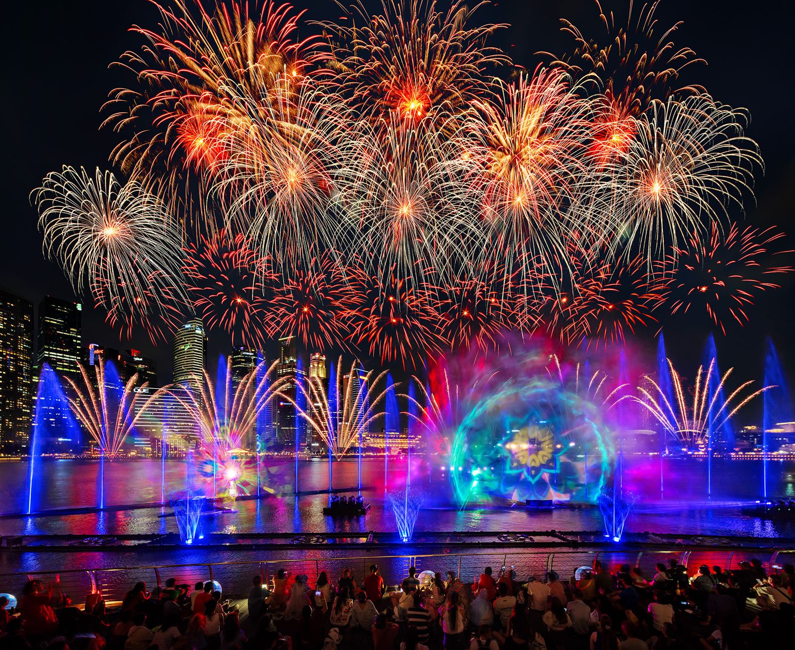 Massive fireworks display over a show crowd at Marina Bay